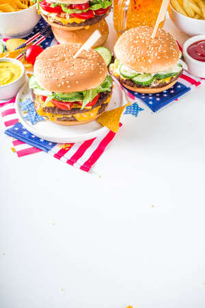 Celebrating Independence Day, July 4. Traditional American Memorial Day Patriotic Picnic with burgers, french fries and snacks, Summer USA picnic and bbq concept, White concrete backgroundの写真素材