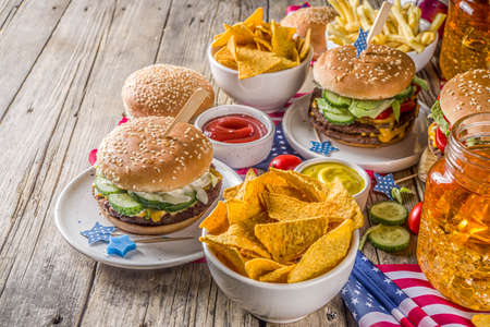 Celebrating Independence Day, July 4. Traditional American Memorial Day Patriotic Picnic with burgers,  french fries and snacks, Summer USA picnic and bbq concept, Old wooden background の写真素材