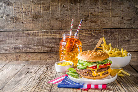 Celebrating Independence Day, July 4. Traditional American Memorial Day Patriotic Picnic with burgers,  french fries and snacks, Summer USA picnic and bbq concept, Old wooden background の写真素材
