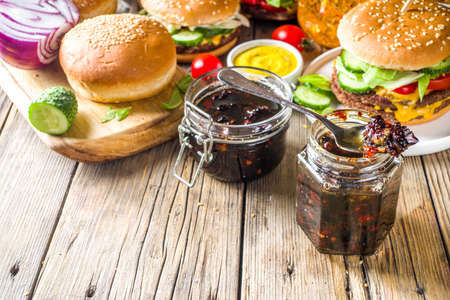 Homemade bacon jam in jars, with bread and burgersの写真素材