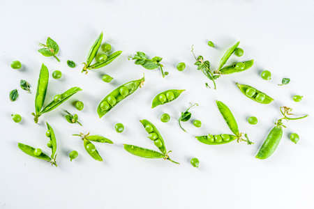 Fresh green pea pods and green peas on the white background, top view 