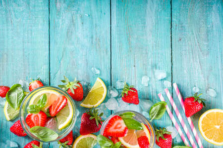 Strawberries and basil lemonade. Summer cold iced cocktail recipe, with fresh strawberry, lemon and basil leaves, wooden background copy spaceの写真素材