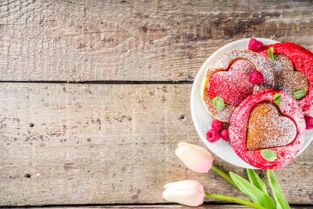 Valentine day brunch food recipe idea. Delicious homemade heart shaped red and white pancakes with berries. Concept of a festive breakfast for Valentine's Day, pleasant surprise for loved oneの写真素材