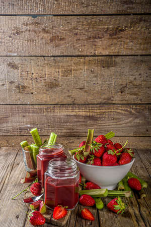 Homemade strawberry rhubarb jam or sauce, with fresh rhubarb and strawberries and spices, wooden rustic background copy space の写真素材