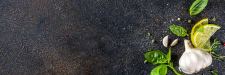 Assortment of spices, herbs and greens. Ingredients for cooking. Food background. Black stone table, Copy space for text. Top view.の写真素材