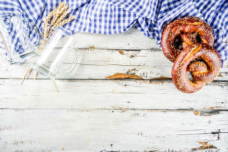 Oktoberfest festive background with traditional Bavarian checkered tablecloth, pretzels and beer mugs.の写真素材