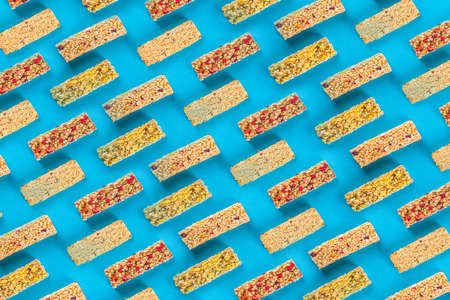 Cereal granola bars pattern blue background, flatlay top view. Healthy cereal snack cpnceptの写真素材