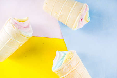Multicolored pastel unicorn rainbow ice cream. Three colorful ice cream waffle cones on bright background copy spaceの写真素材