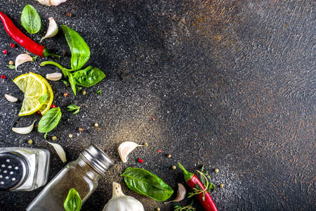 Assortment of spices, herbs and greens. Ingredients for cooking. Food background. Black stone table, Copy space for text. Top view.の写真素材