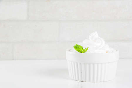 Frozen white vanilla frozen yogurt or soft ice cream in white bowl copy space