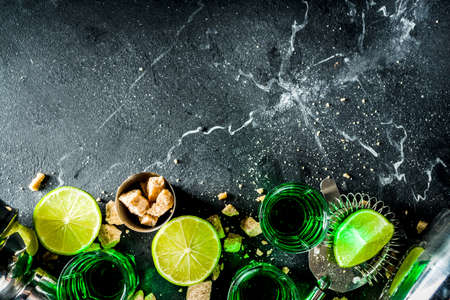 Strong alcohol. Absinthe with sugar, ice cubes and lime slices, Three shot glasses with absinthe....