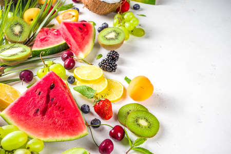 Assorted different summer tropical fresh raw fruits and berries. Clean eating, healthy lifestyle, diet and vitamin concept. Top view flatlay white table backgroundの写真素材