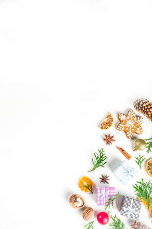 Christmas festive background with xmas fir tree branches, pine cones and decorations on white. Flatlay, top view copy space.の写真素材
