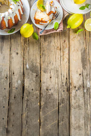 Homemade lemon bundt cake with sugar icing, fresh lemons and mint leaves, copy spaceの写真素材