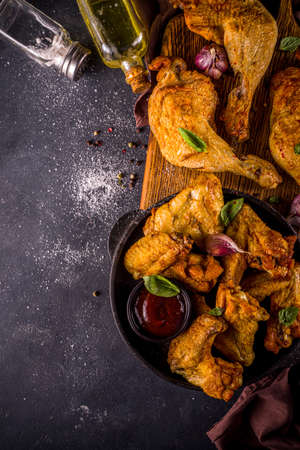 Grilled chicken legs and wings, with herbs, spices, garlic and barbeque sauce, dark concrete table background copy space top viewの写真素材