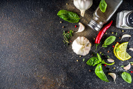 Assortment of spices, herbs and greens. Ingredients for cooking. Food background. Black stone table, Copy space for text. Top view.の写真素材