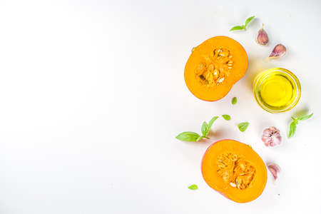 Autumn food cooking concept. Pumpkin cooking background, with half sliced pumpkin, olive oil and spices top view copy spaceの写真素材
