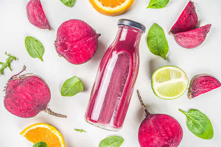Beetroot smoothie in small portioned bottle, with fresh beet slices and lime, flatlay on white backgroundの写真素材