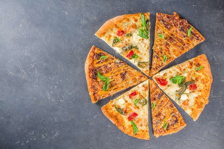 Various italian american traditional pizza slices. Slices of delicious pizza on dark gray concrete background, top view flatlayの写真素材