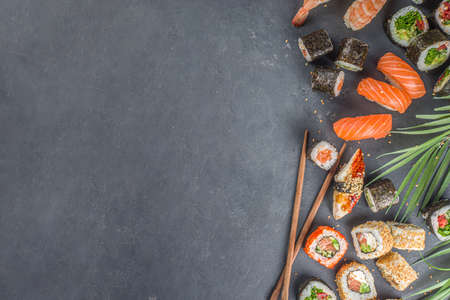 Sushi set with chopsticks. Various delicious japanese sushi, roll pieces and nigiri on light blue backgroundの写真素材