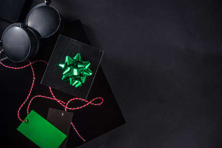 Christmas Clearance and Sale Concept. Black Friday, Green Monday (Cyber Monday) Sale. With Discount Price Tags, Black gadgets and accessories, Shopping Bag. Flat lay top view, black matte backgroundの写真素材
