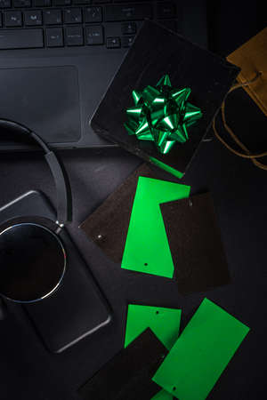 Christmas Clearance and Sale Concept. Black Friday, Green Monday (Cyber Monday) Sale. With Discount Price Tags, Black gadgets and accessories, Shopping Bag. Flat lay top view, black matte backgroundの写真素材