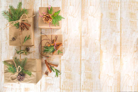 Christmas Background with Gift Boxes Wrapped in Craft Paper on white table. Preparation for...