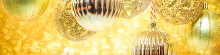 Christmas Shining gold background, with golden Christmas Balls ans Baubles, on Glittering Gold Bokeh...
