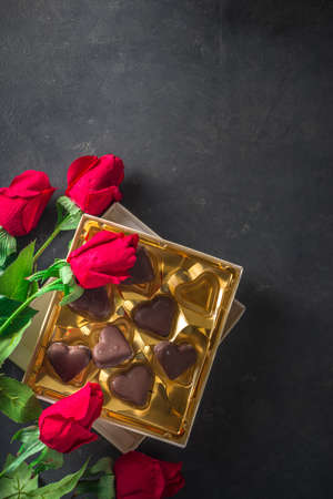 Valentine day background with Chocolates Hearts and Red Roses. Over Black Stone table Backdrop, top viewの写真素材