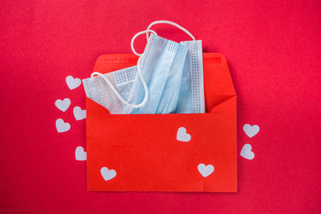 Valentine Day greeting card background with red greeting envelope, face mask and hearts. New normal...