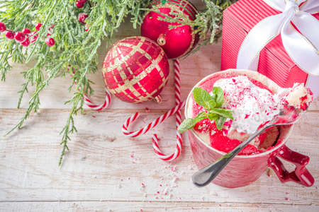 Candy cane peppermint mugcake. Simple Christmas breakfast, snack idea recipe, white and red swirled sponge cake in festive mugs with whipped cream and candy cane pieces toppingの写真素材