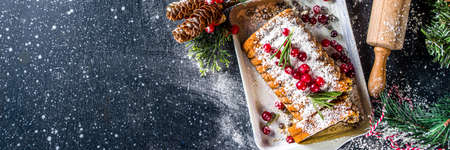 Traditional christmas baking, Festive Xmas fruitcake with dryed fruits, liquer, and cranberry decor. Homemade fruitcake on Chritmas decorated backgroundの写真素材