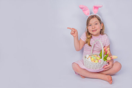 Happy cute girl with bunny ears. Easter greeting card background. with Easter eggs and spring flower...