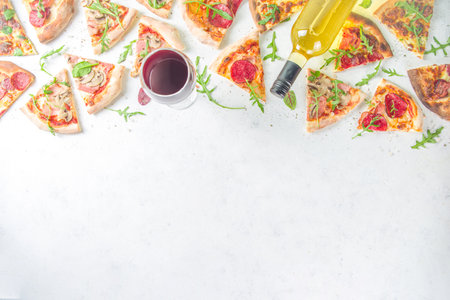 Pizza party concept. Set of pizzas with various fillings, Pieces of different pizza, glass and bottle with wine. Flatlay top view copy space on white backgroundの写真素材