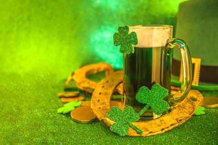 St Patrick's Day Pub Bar menu background. Green Beer In Glass with And with horseshoe, shamrock clover decor, gold coins, on green bokeh glittering background. St Patrick's holiday greeting card mock upの写真素材
