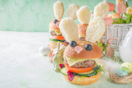 Delicious fresh homemade bunny burgers for Easter kids party. Creative burgers in form of rabbits, with funny rabbit muzzle and ears, with Easter decor copy spaceの写真素材