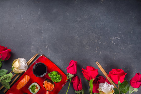 Valentine day festive dinner idea. Menu, invitation background for Valentine day sushi roll set, with heart shaped decor and rose flowers bouquet. Top view with copy space for textの写真素材
