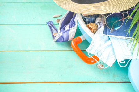 Beach and Vacation Holiday Accessories On Blue Plank. Suitcase for travel, summer women's clothing,...