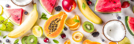 Assorted different summer tropical fresh raw fruits and berries. Clean eating, healthy lifestyle, diet and vitamin concept. Top view flatlay white table backgroundの写真素材