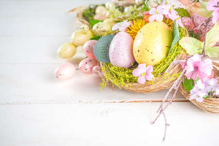 Happy easter background with Nests decoration, colorful eggs and Spring Flowers. Caster card on...