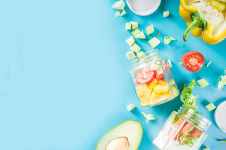 Healthy take-away lunch jar. Vegan vegetable salad in glass jars, with sliced fresh vegetables....