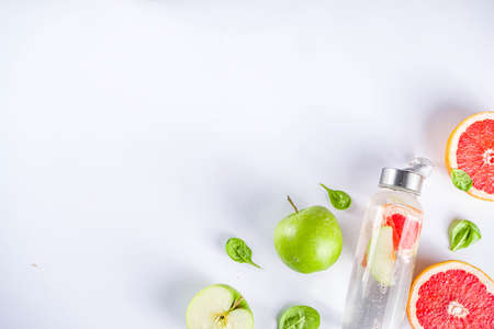Balanced nutrition diet, fitness lifestyle concept. Fresh infused drink in glass jar. Detox water, lemonade with grapefruit and green apple. Top view flat lay backgroundの写真素材