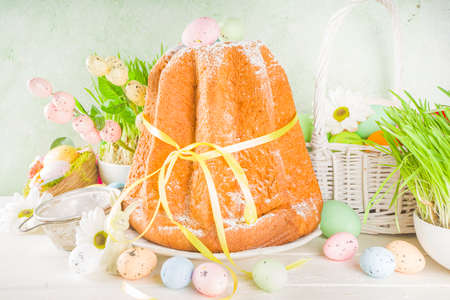 Easter sweets and decorations background, Sweet easter cake panettone with colorful painted eggs,...