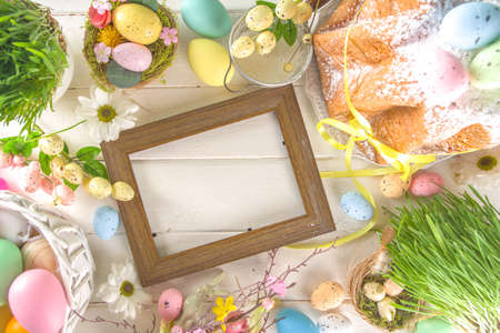 Easter sweets and decorations background, Sweet easter cake panettone with colorful painted eggs, spring grass and decor, copy space for textの写真素材