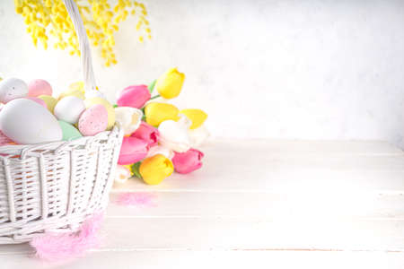 Happy easter background with colorful eggs in basket and Spring Flowers. Easter spring holidat greeting card backgroundの写真素材