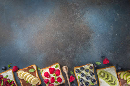 Healthy fruit and berry sandwiches. Tasty diet toast bread with cream cheese and banana, apple,...