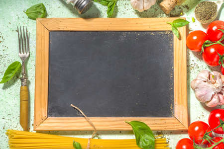 Mediterranean food cooking background, fresh tomatoes, basil, olive oil and garlic on light green background copy space top viewの写真素材