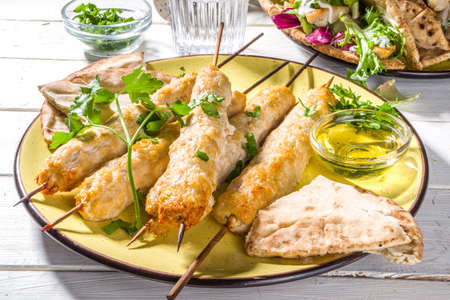 Chicken shish kebabs on wooden skewers sticks top view. Traditional Mediterranean dish kebaps with...