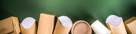 Cardboard fast food and drink packaging concept. Set of various takeaway foods containers on green...