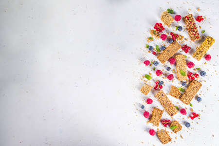 Healthy snack concept, Cereal granola bars with fresh berries and nuts on white background copy spaceの写真素材